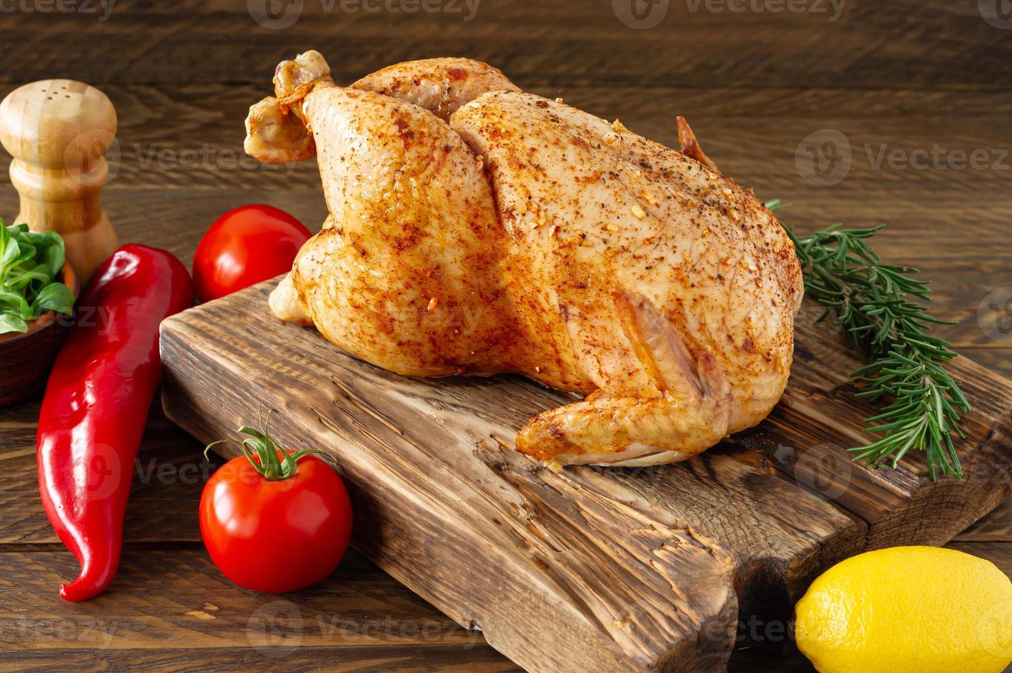 pollo asado con especias sobre fondo de madera. comida saludable, dieta o concepto de cocina foto