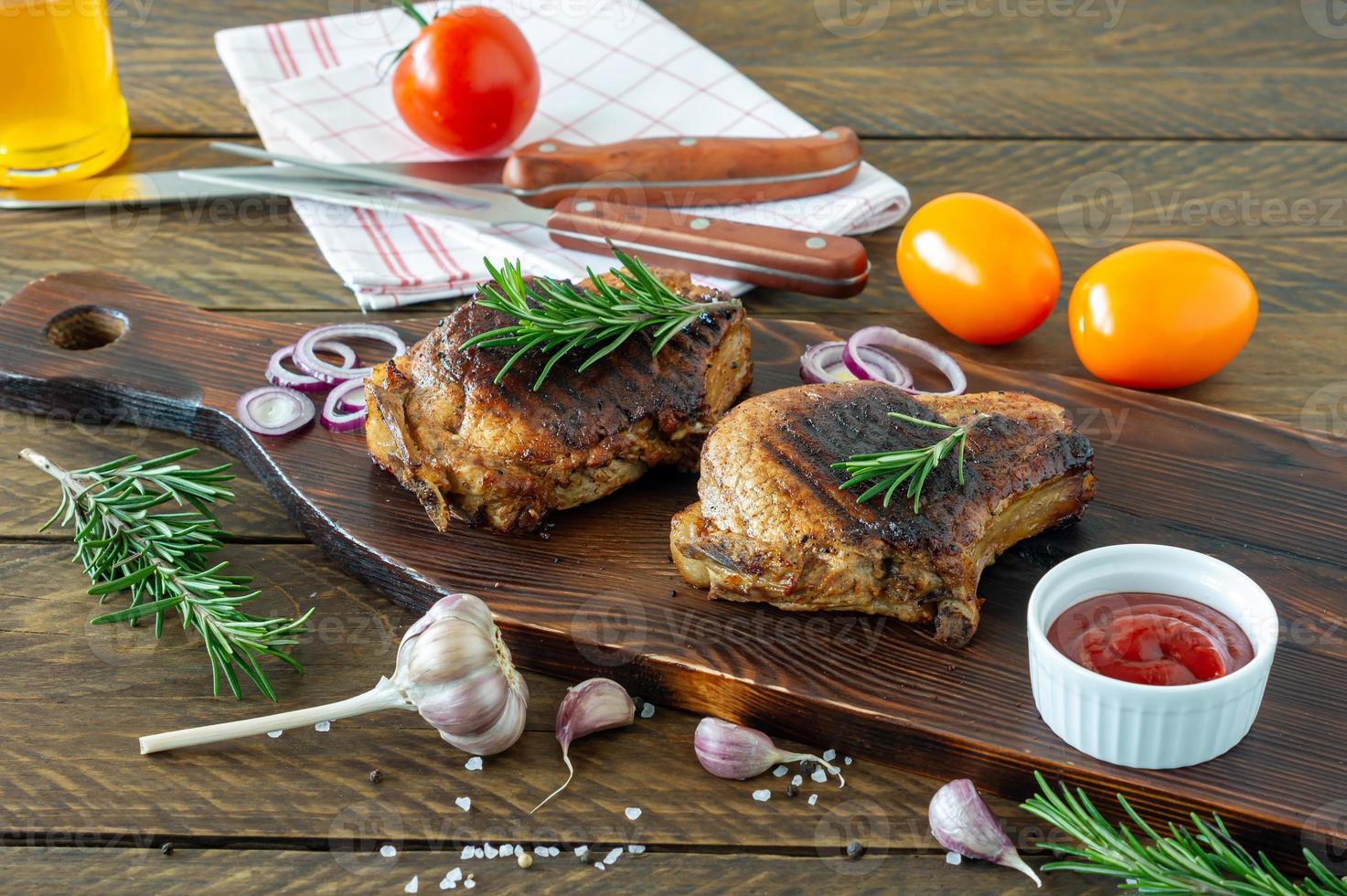 Fresh juicy roasted red meat on wooden board, with spices and vegetables. Restaurant food, delicious dish photo