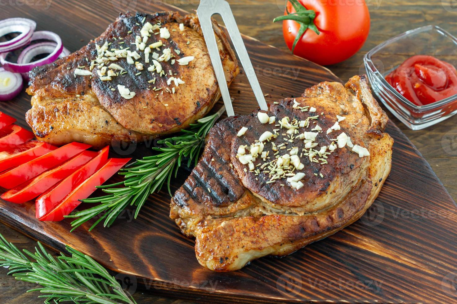 carne roja fresca y jugosa asada sobre tabla de madera, con especias y verduras. comida de restaurante, plato delicioso foto