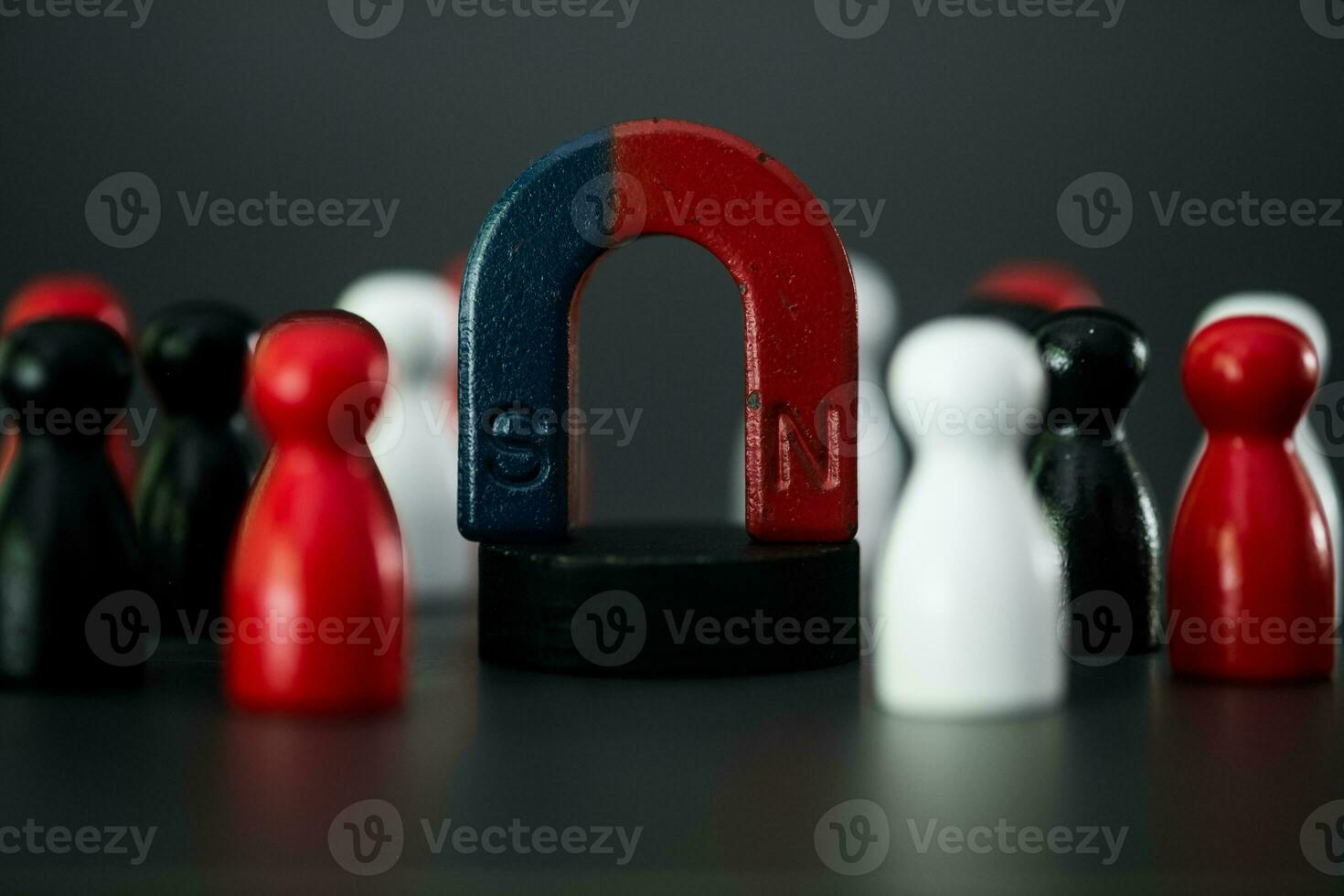 The magnet was put in the center with many wooden figures around. Recruiting new workers and staff for specialists. photo