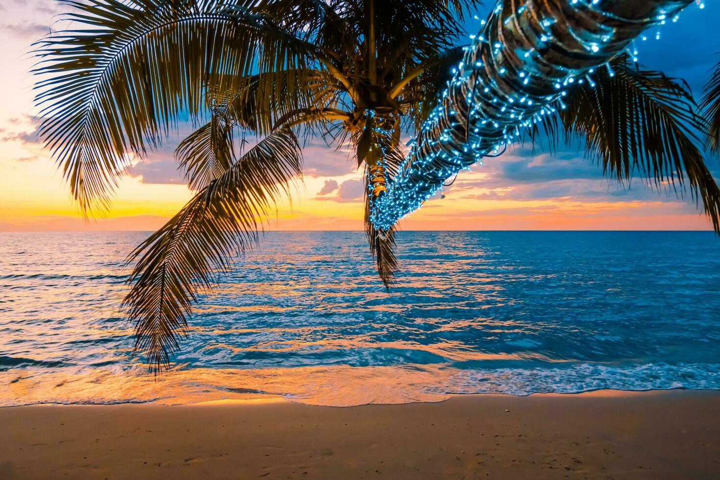 hermosa playa tropical al atardecer con palmeras e iluminada para viajar en tiempo de relajación de vacaciones, foto