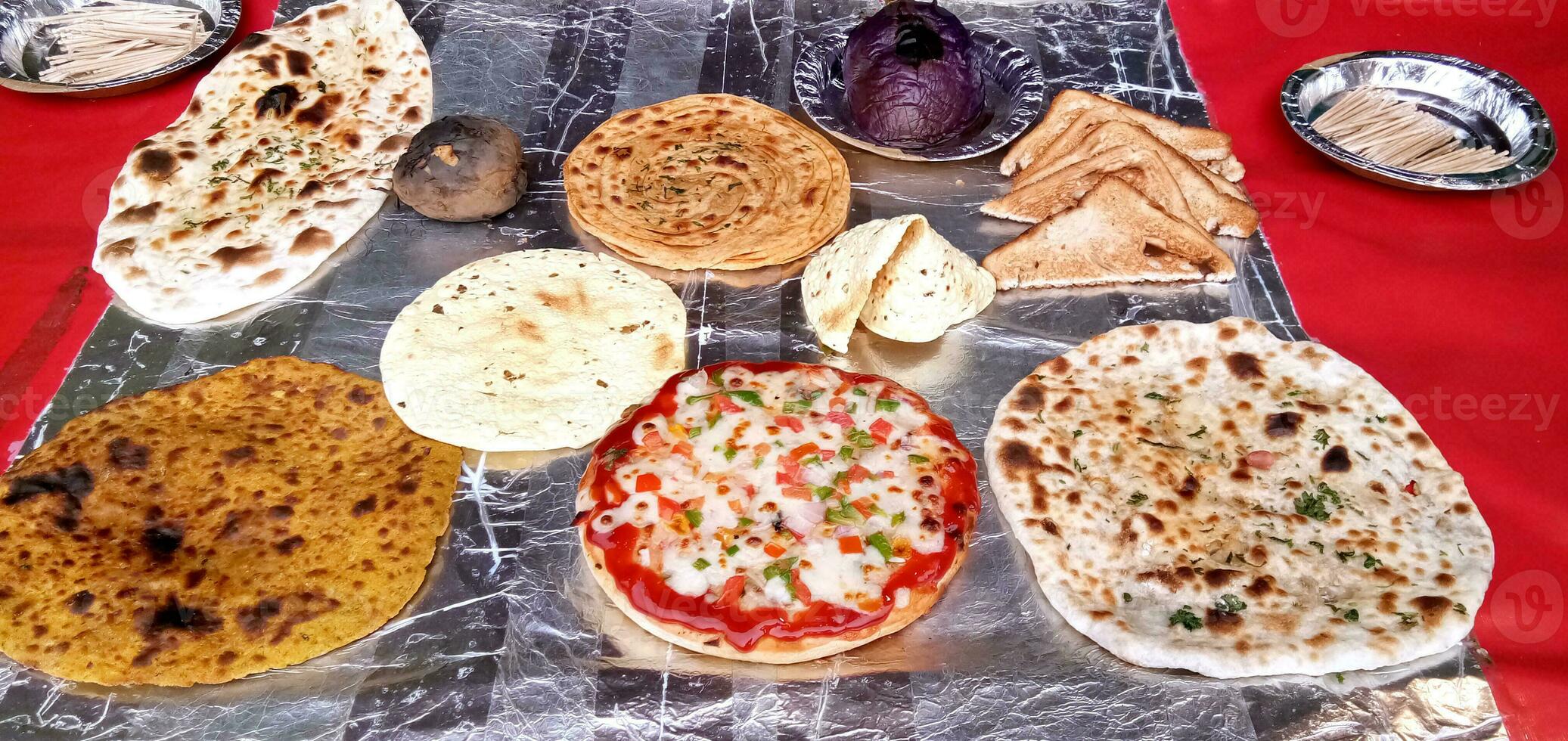 Variety of cooked chapati, prantha, pizza and other food photo