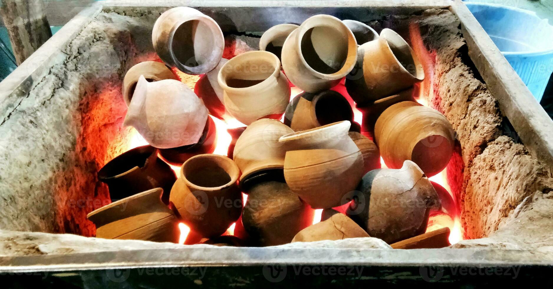 Heating clay pots in coal to make tea photo