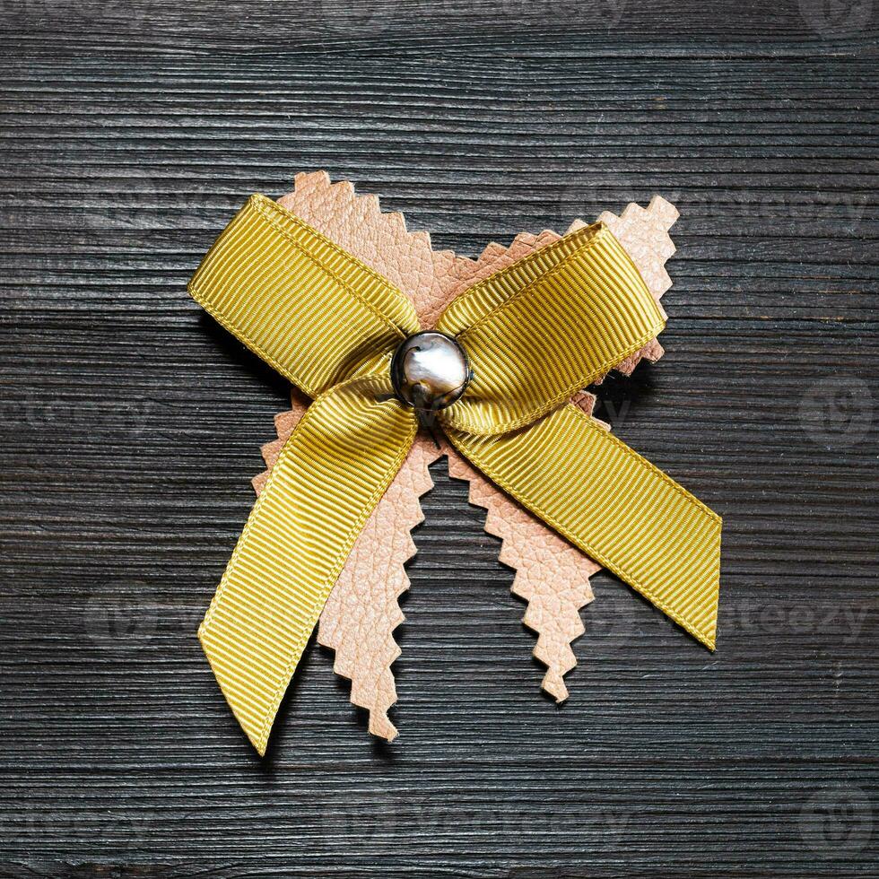 top view of bow brooch from leather and ribbon photo