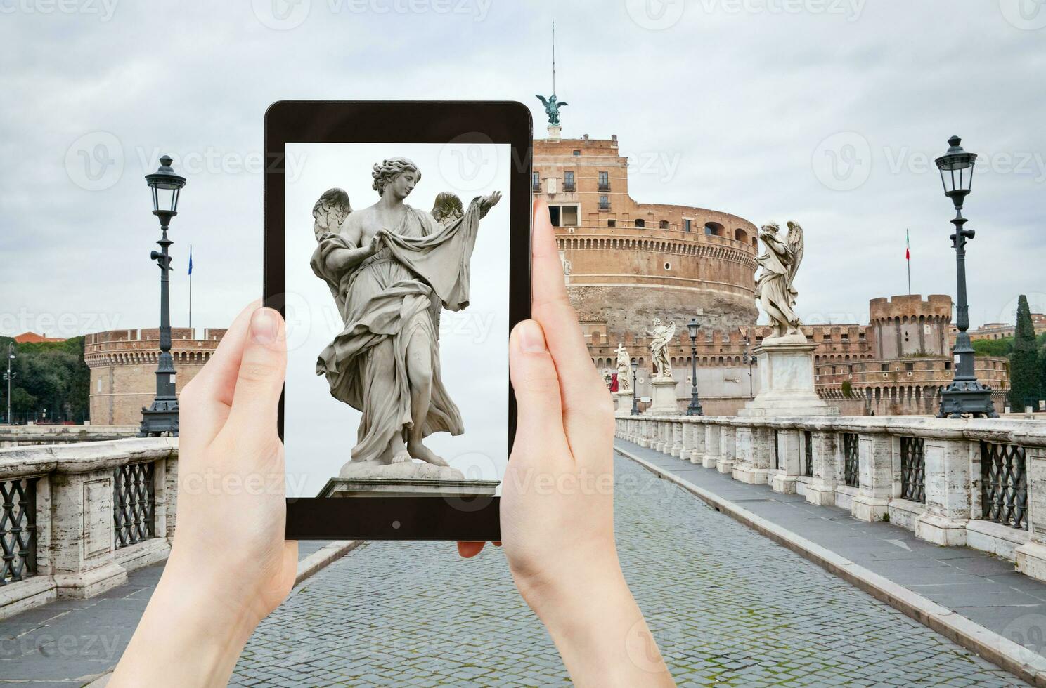 tomando una foto de la estatua en el puente de st angel, roma