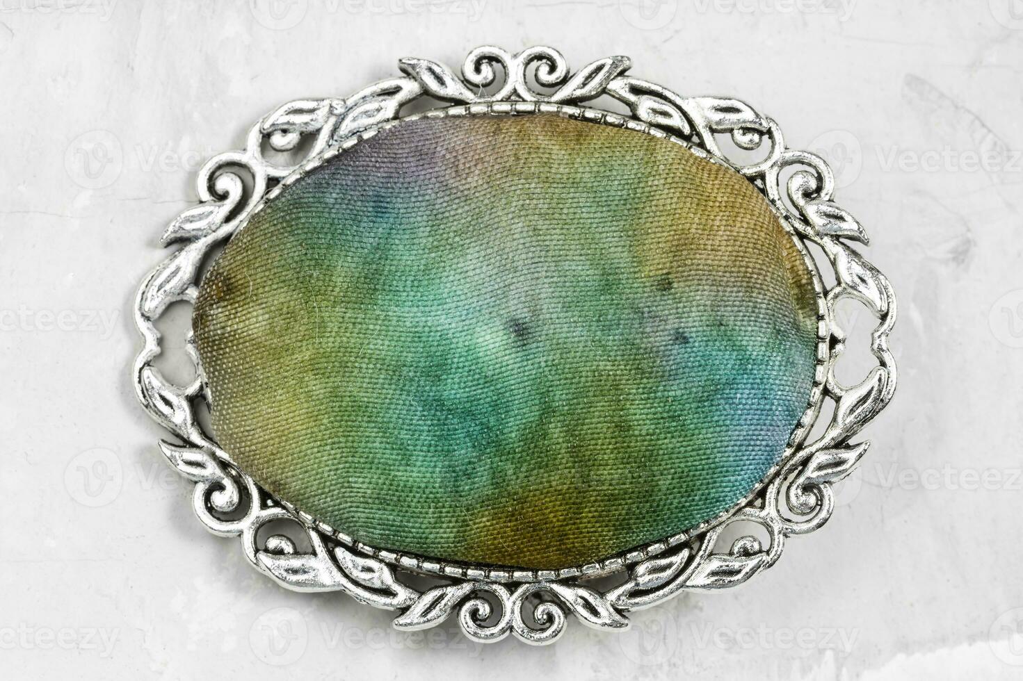 silver brooch with hand-colored silk batik on gray photo