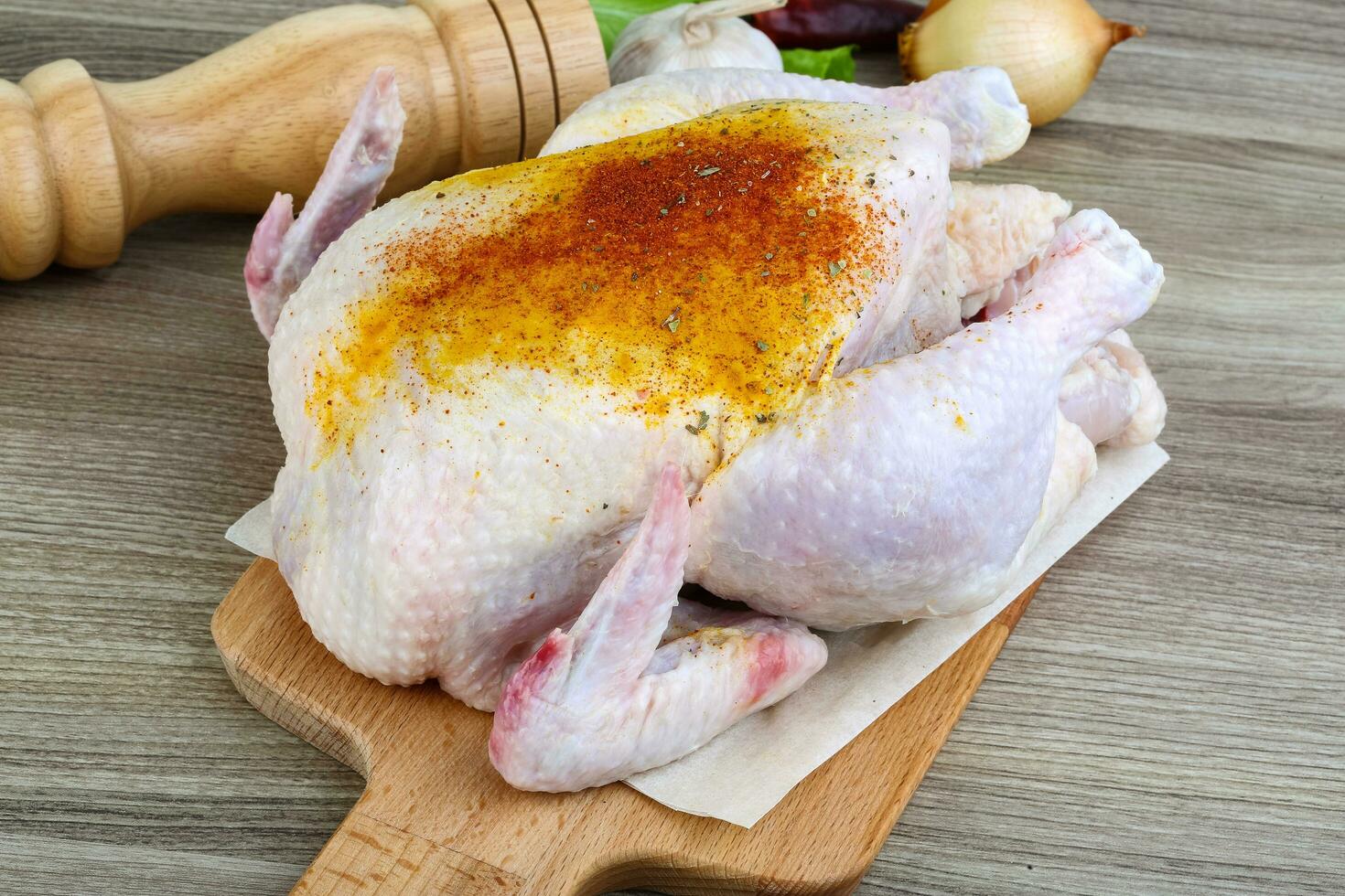 Raw chicken on wooden board and wooden background photo