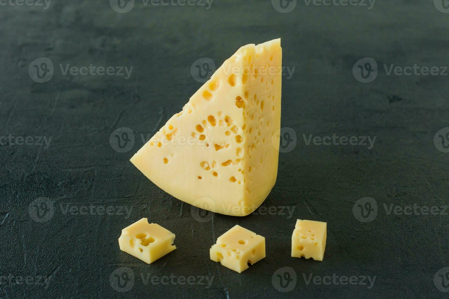 queso radamer en un plato servido con miel. trozo triangular de queso suizo de leche de vaca amarillo con agujeros foto