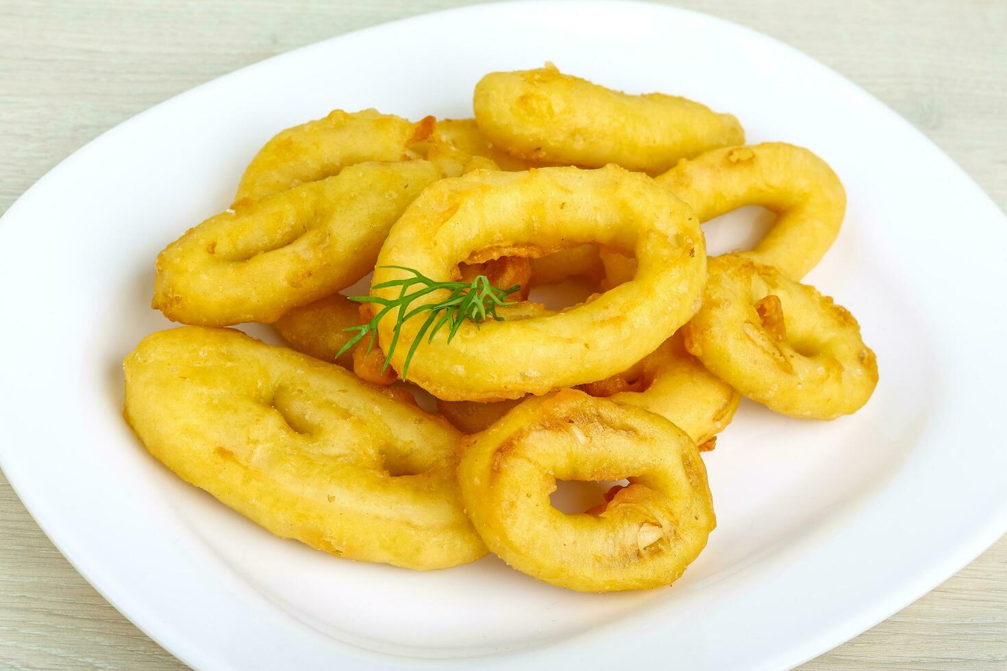 anillos de calamares en el plato y fondo de madera foto