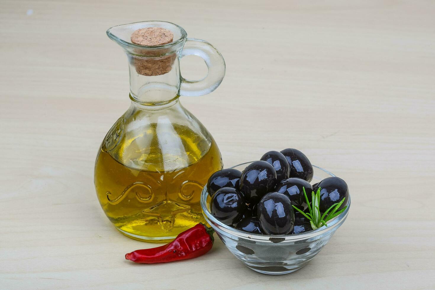 Olive oil in a bowl on wooden background photo