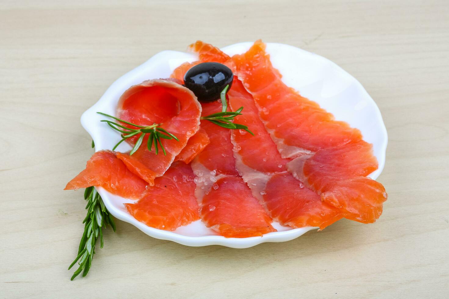 salmón en rodajas en el plato y fondo de madera foto