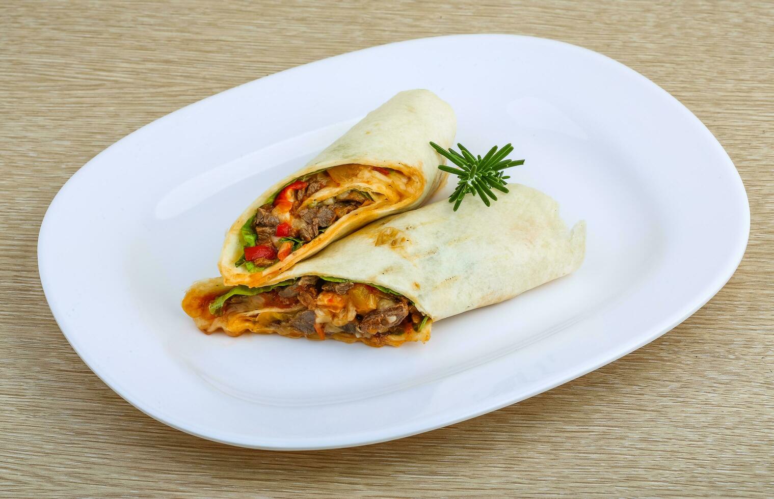 Wrap tortilla on the plate and wooden background photo