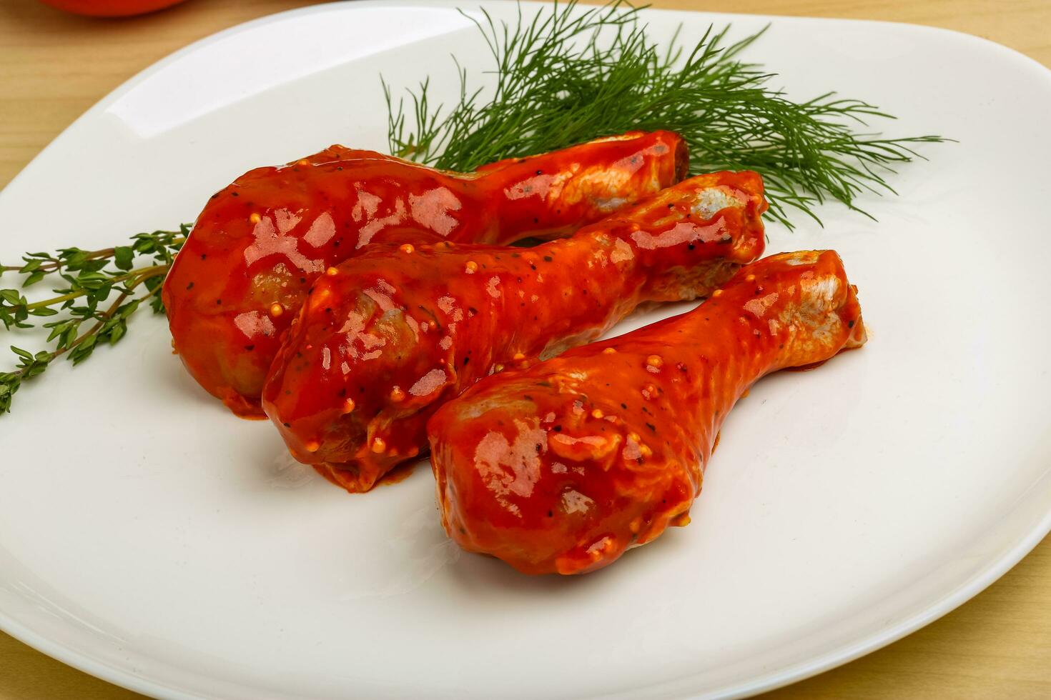 Chicken legs on the plate and wooden background photo