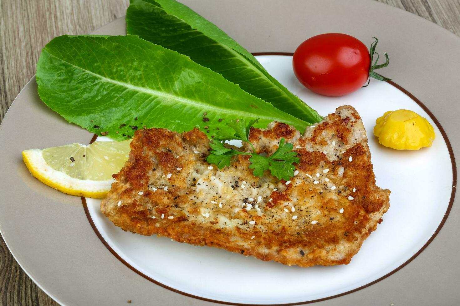 Pork schnitzel on the plate and wooden background photo