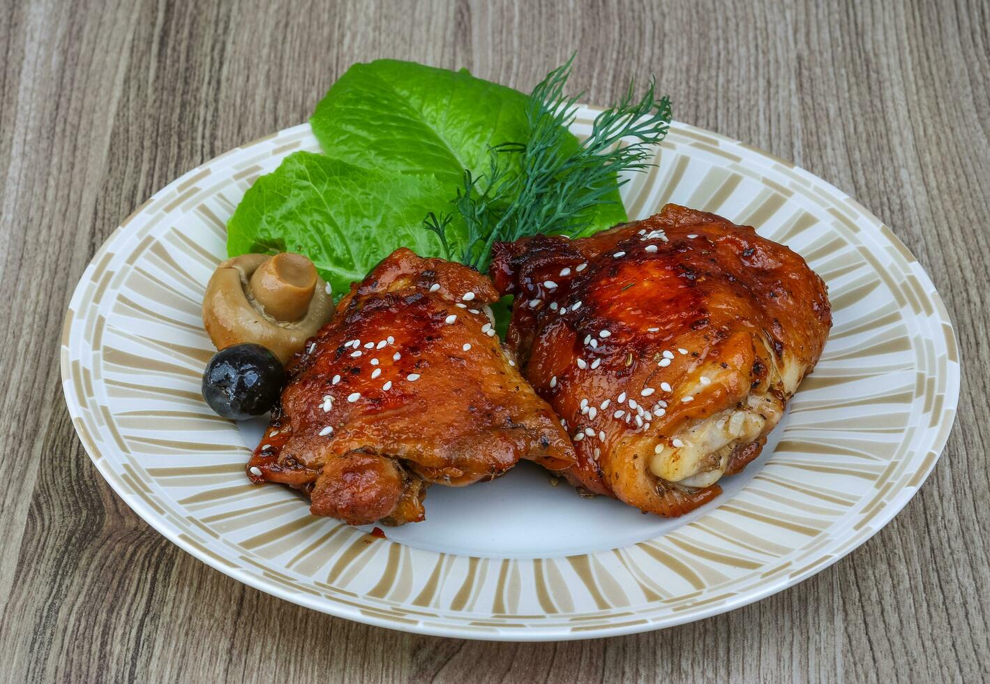 pollo teriyaki en el plato y fondo de madera foto