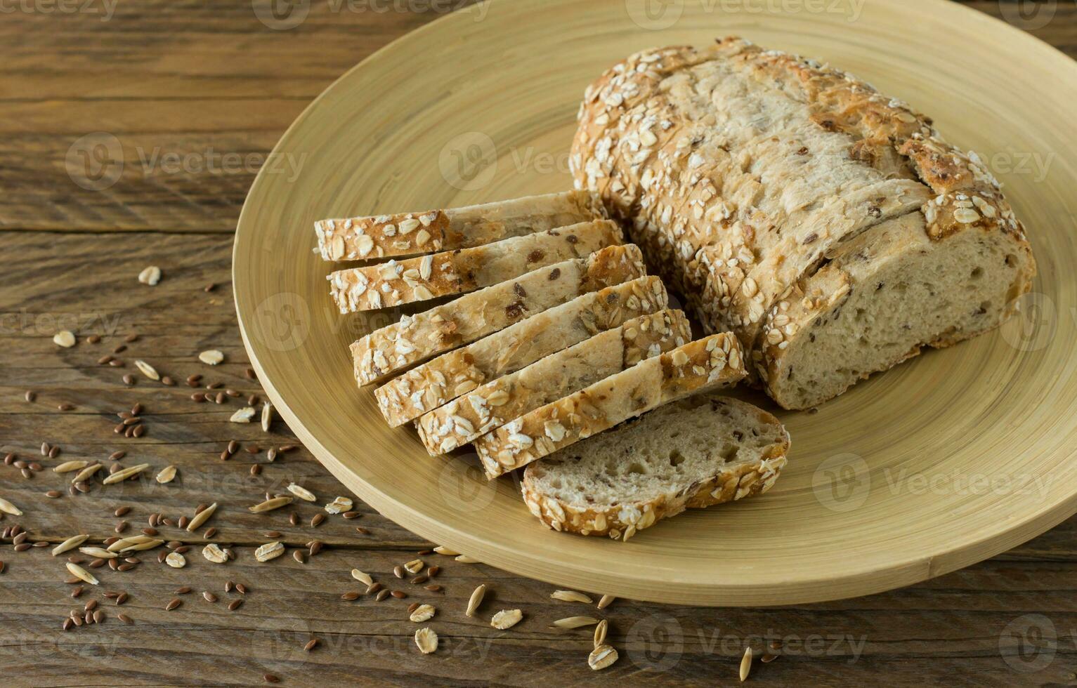 Gluten-free vegan bread with no animal products. Vegetarian bread with oatmeal, banana flavor on a plate on a wooden rustic table, sliced and ready to serve. photo