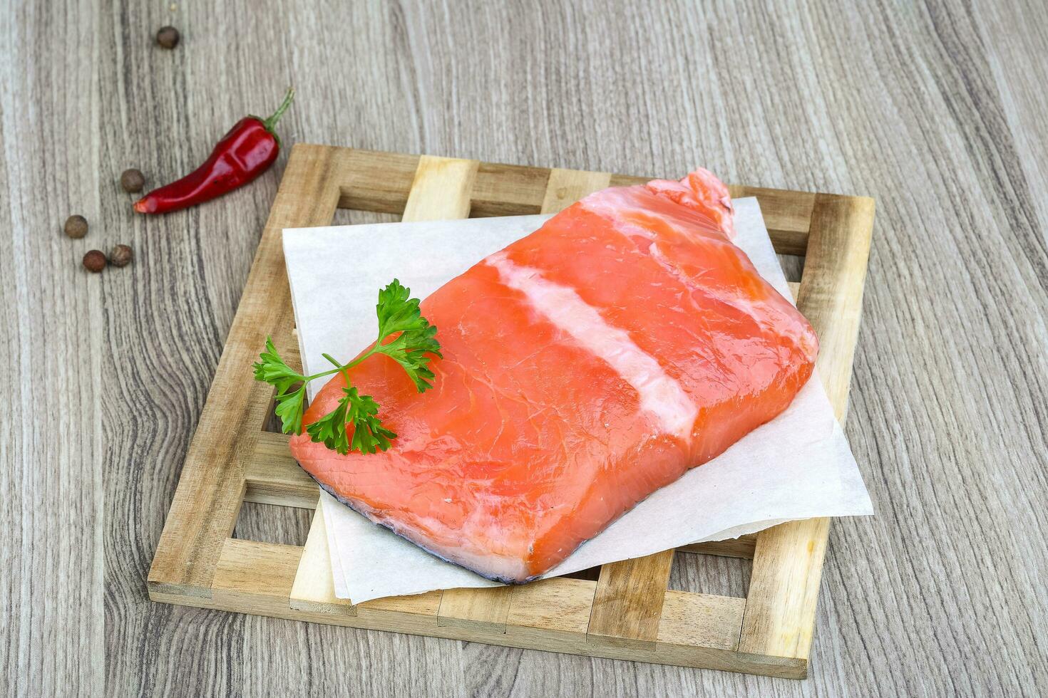 Salmon fillet on wooden board and wooden background photo