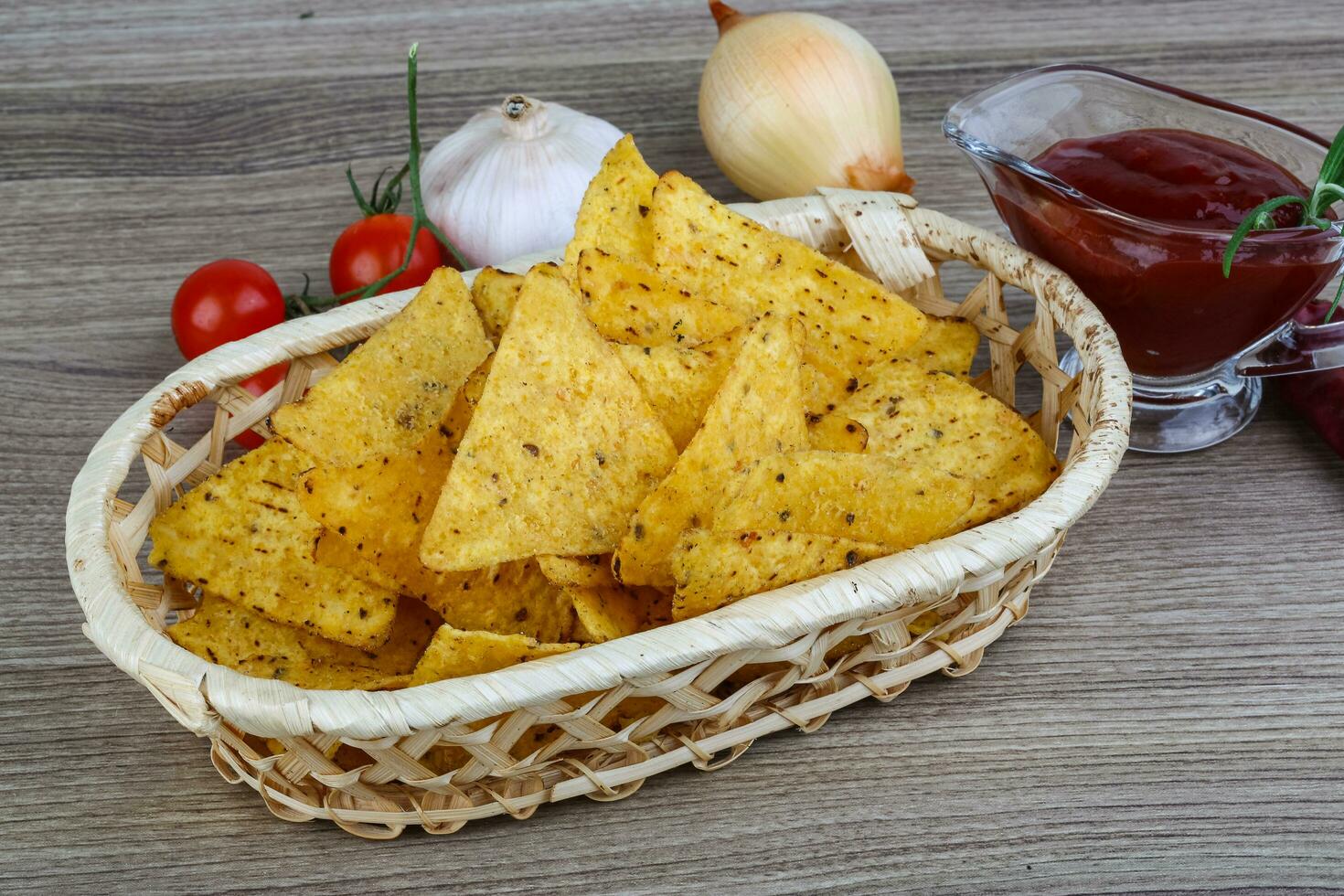 Nachos in a basket on wooden background photo