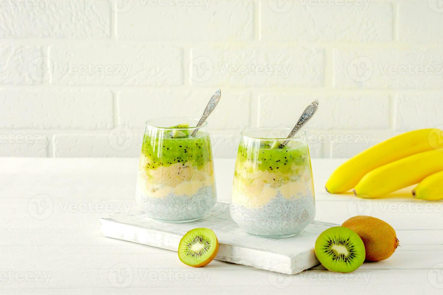 Chia seed pudding with kiwi, banana and mango. Health detox breakfast in glasses on white background photo
