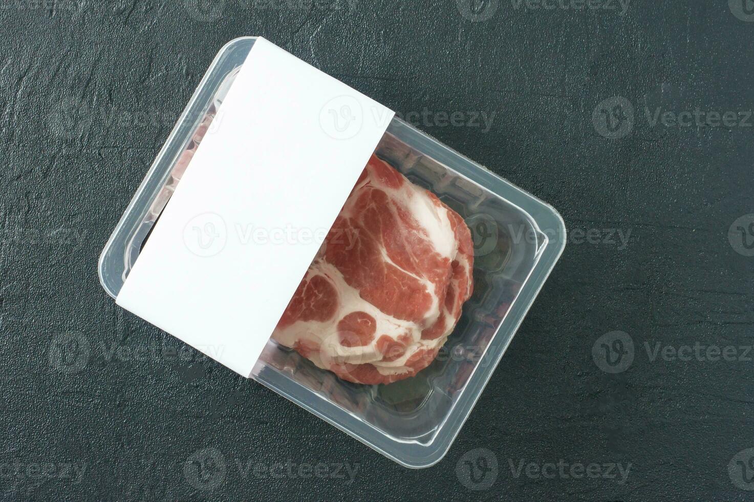 filete de cerdo de mármol crudo en envase al vacío sobre fondo negro, vista superior, maqueta de logotipo para el diseño foto