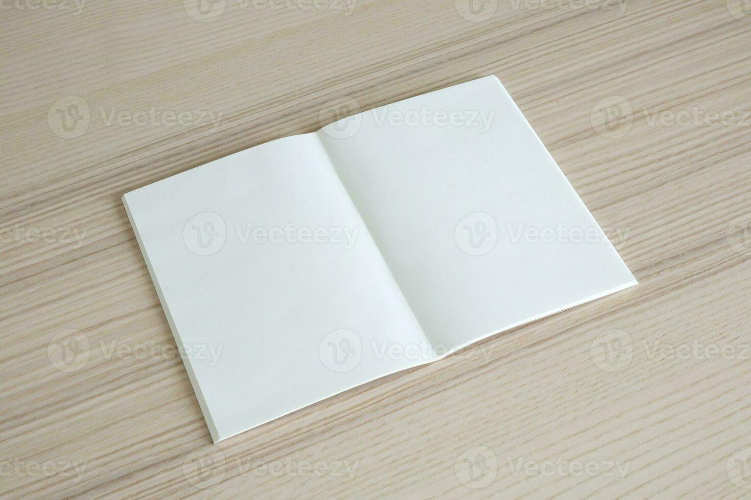 Mock up blank open paper book on wood table background photo