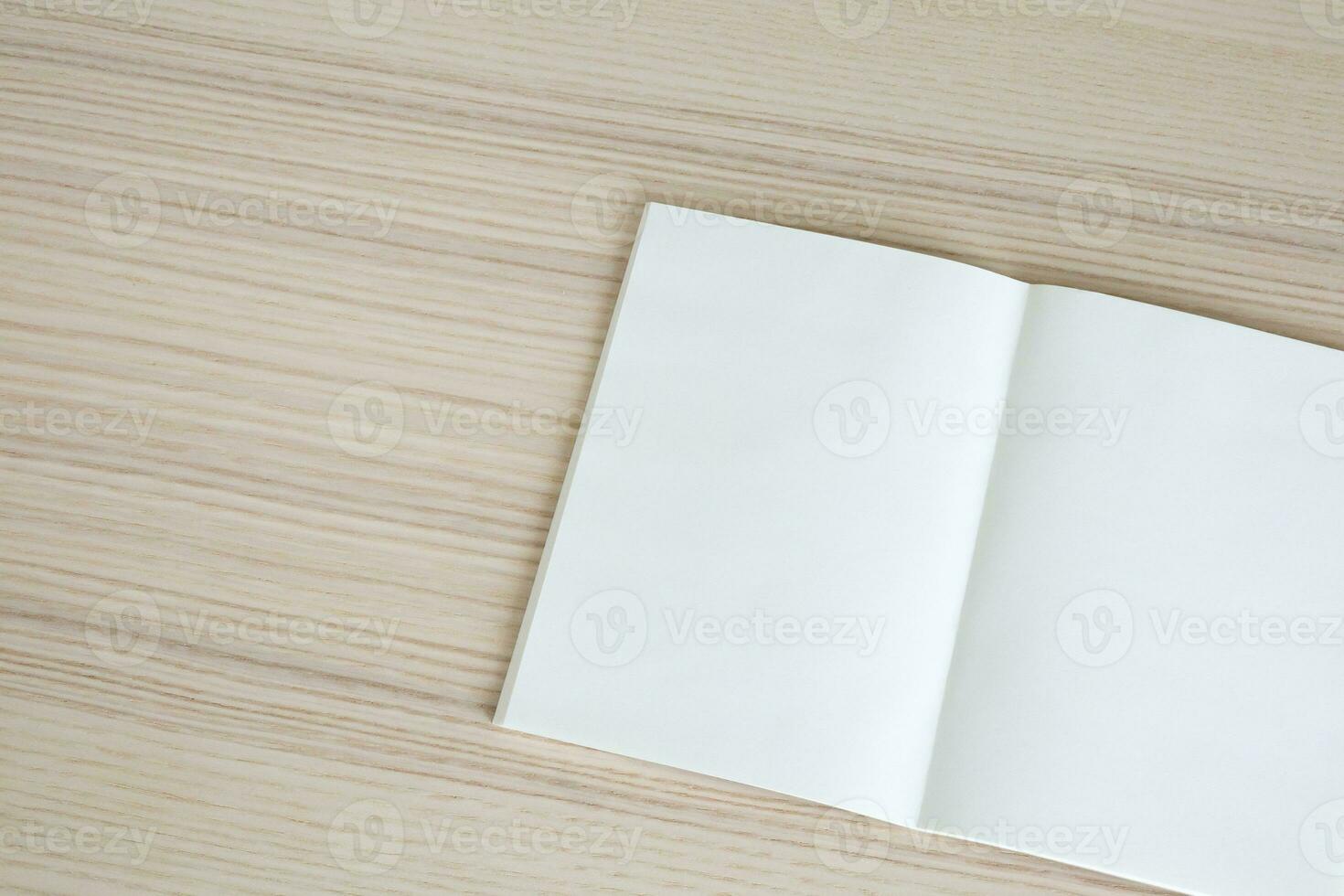 Mock up blank open paper book on wood table background photo