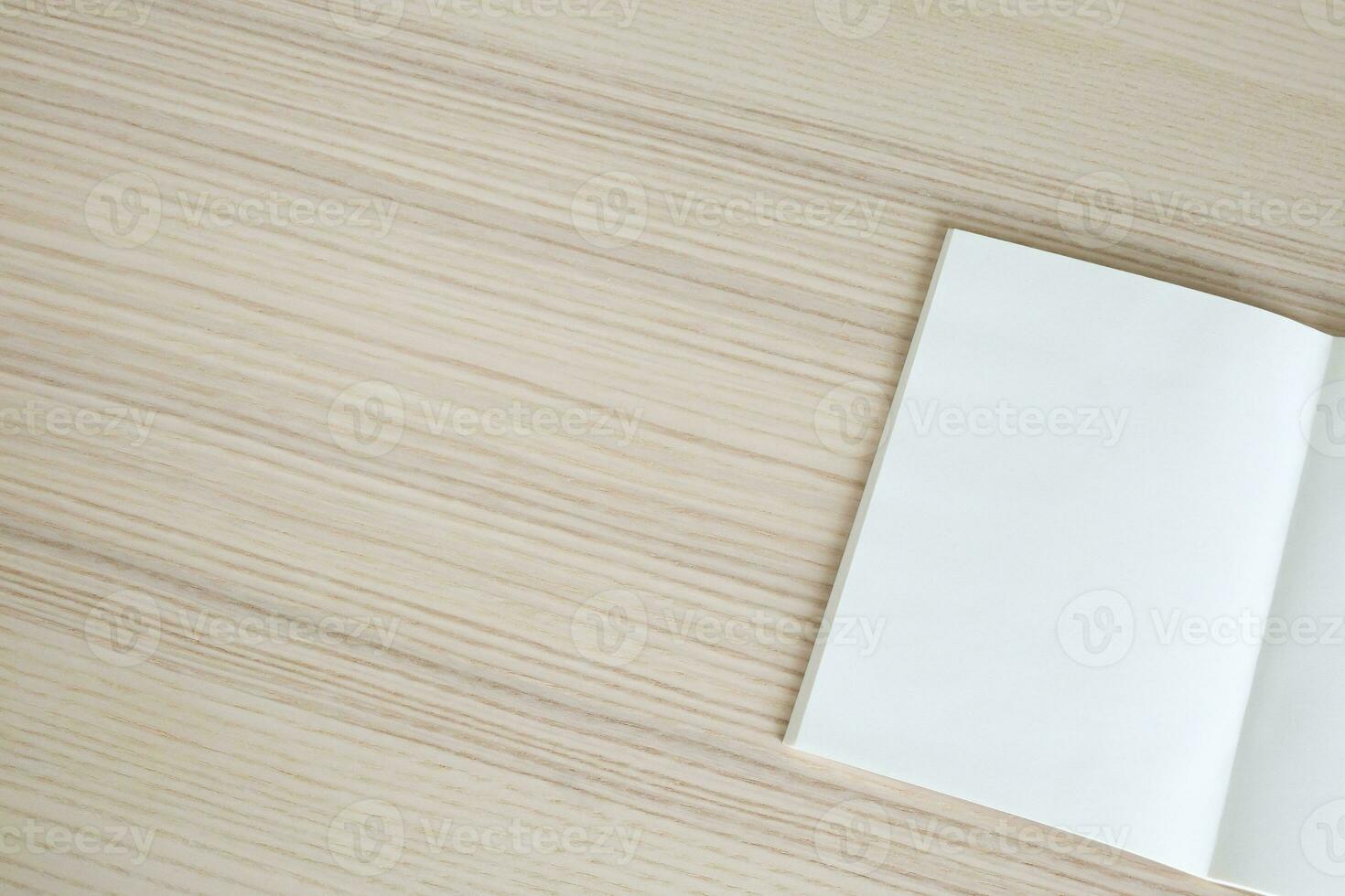 Mock up blank open paper book on wood table background photo