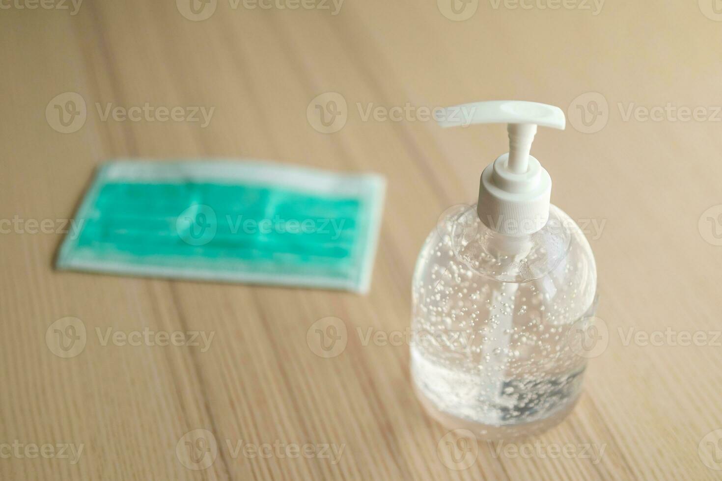 Medical face mask with alcohol sanitizer gel hand wash on wood table for covid-19 Coronavirus prevention concept photo