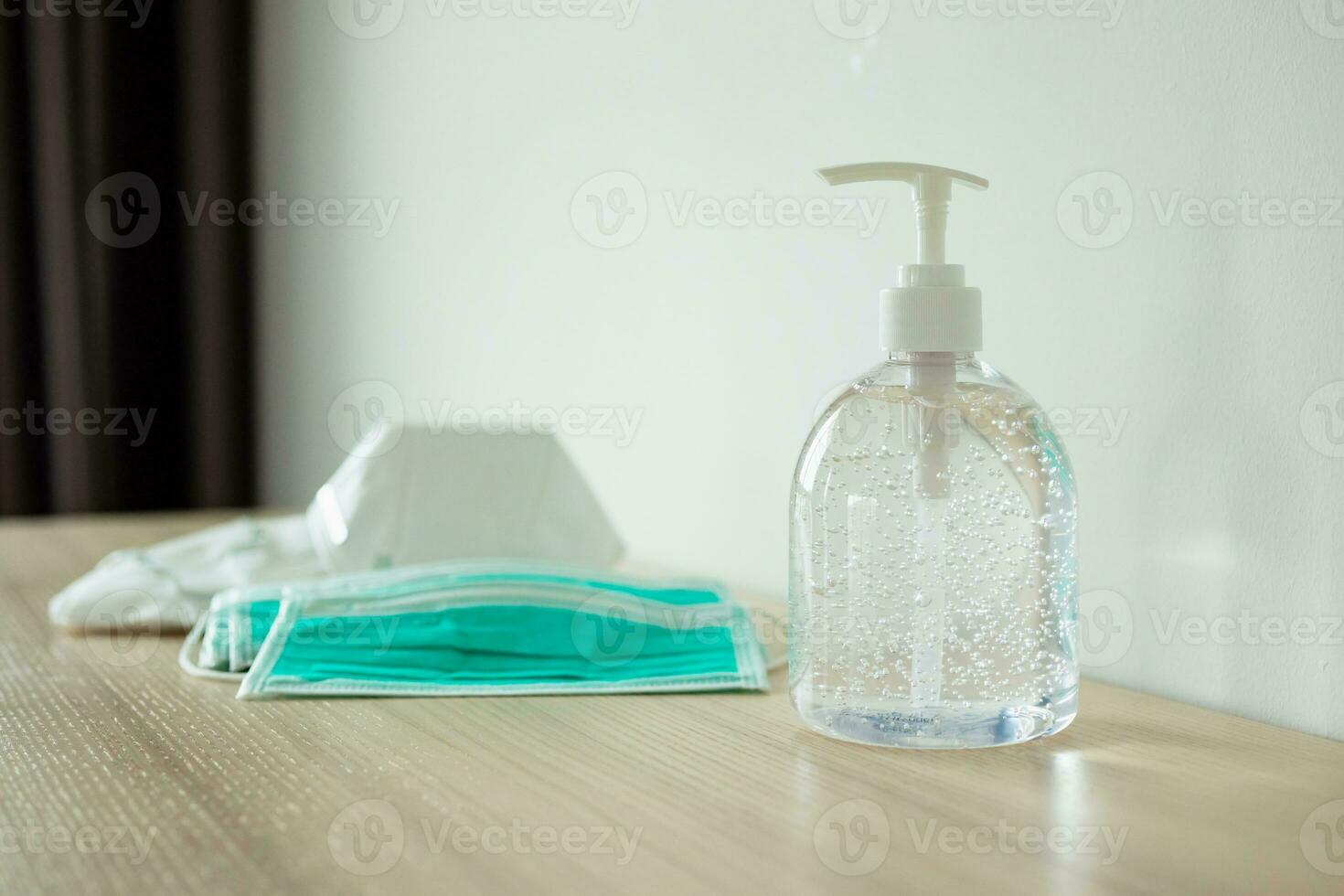 Medical face mask with alcohol sanitizer gel hand wash on wood table for covid-19 Coronavirus prevention concept photo