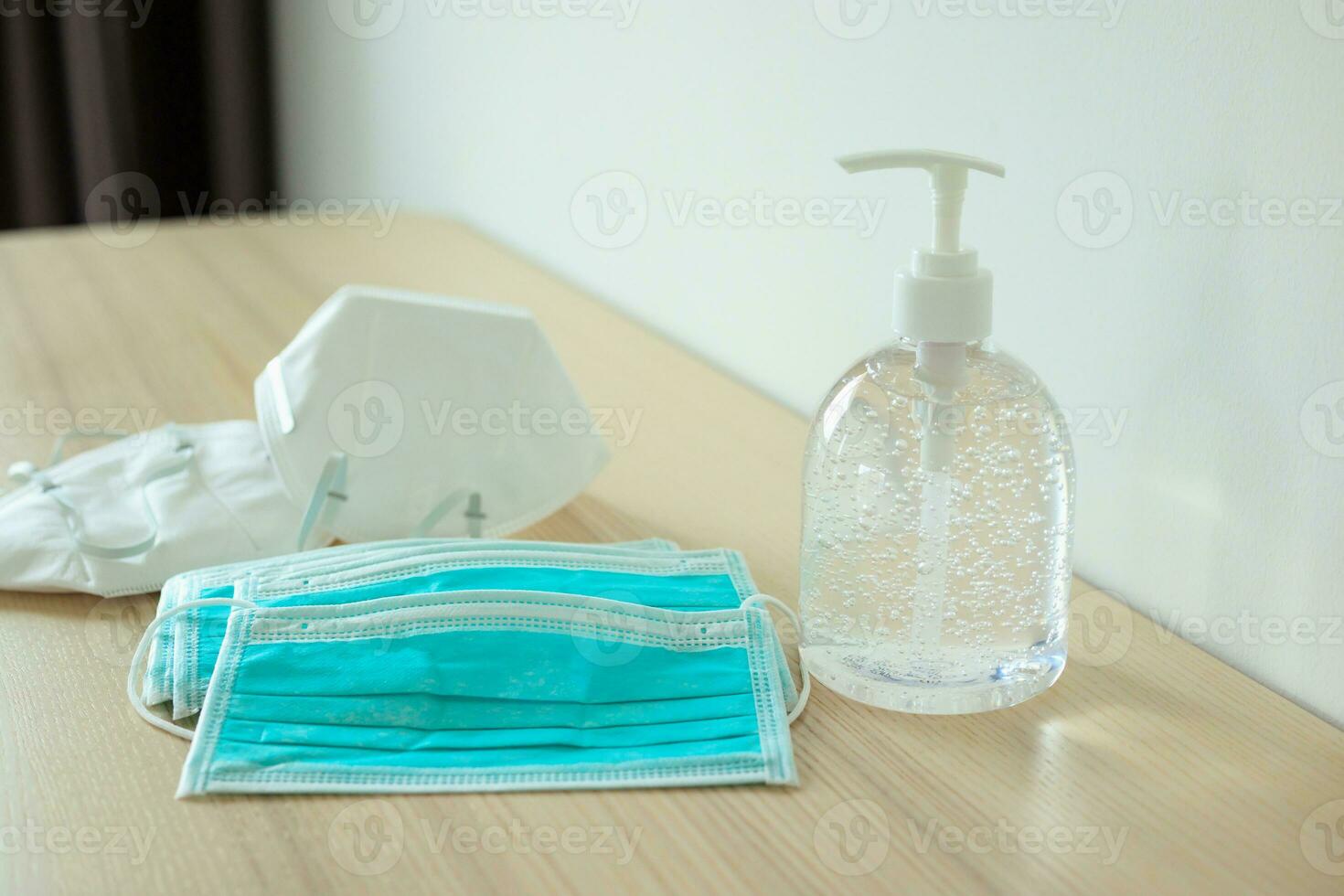 Medical face mask with alcohol sanitizer gel hand wash on wood table for covid-19 Coronavirus prevention concept photo