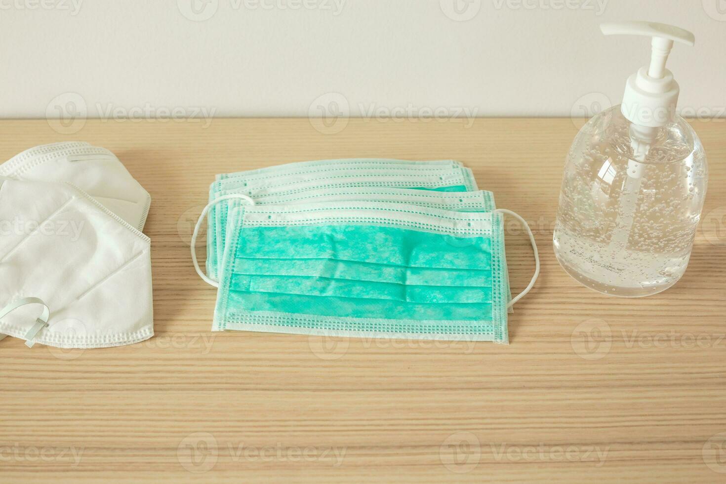 Medical face mask with alcohol sanitizer gel hand wash on wood table for covid-19 Coronavirus prevention concept photo