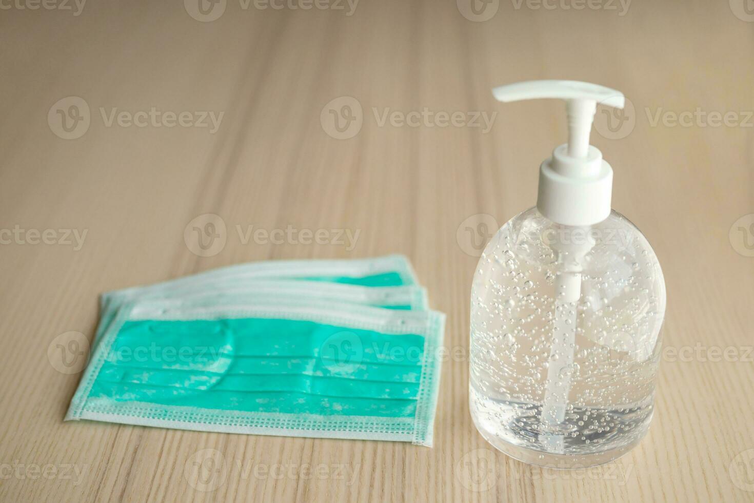 Medical face mask with alcohol sanitizer gel hand wash on wood table for covid-19 Coronavirus prevention concept photo