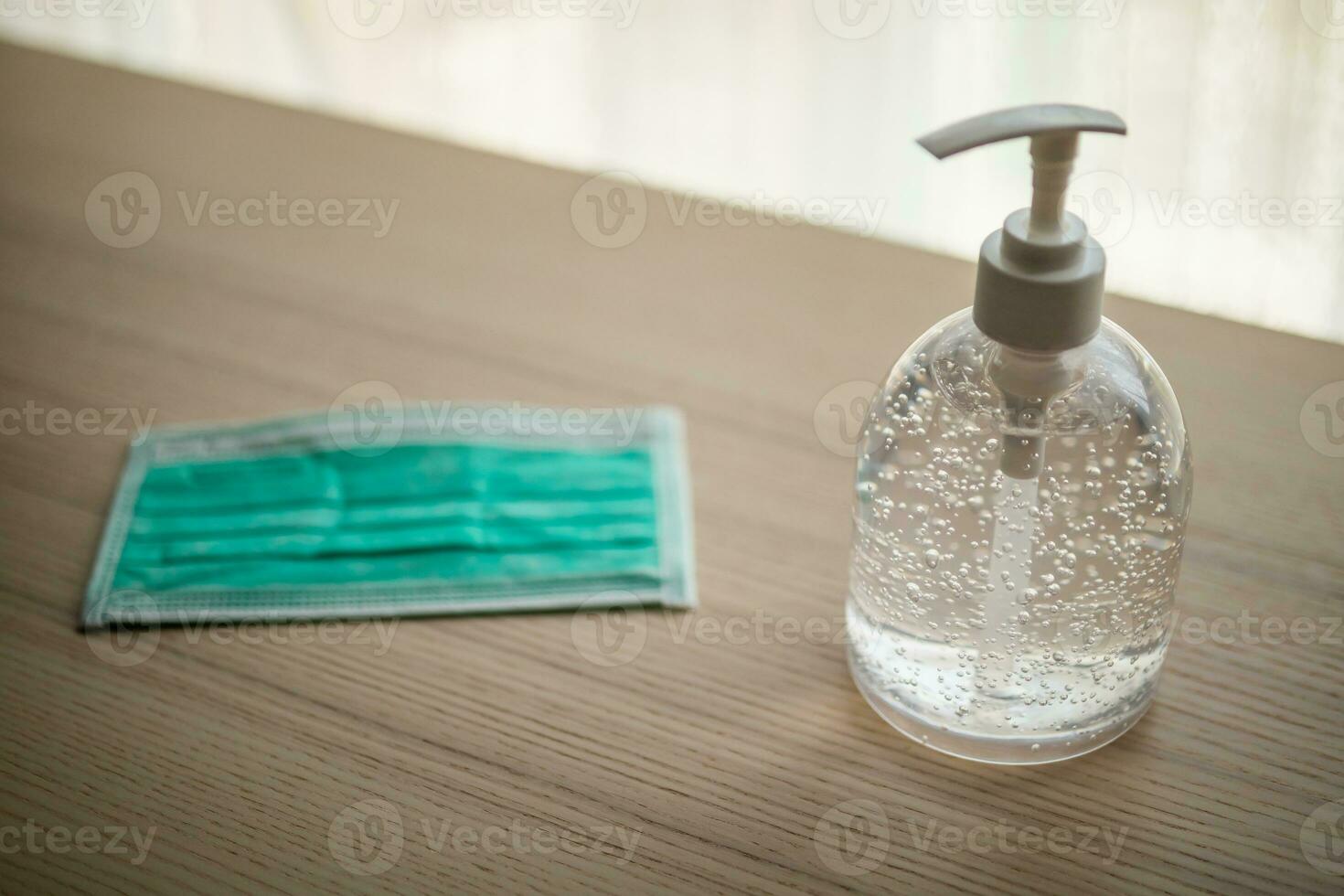 Medical face mask with alcohol sanitizer gel hand wash on wood table for covid-19 Coronavirus prevention concept photo