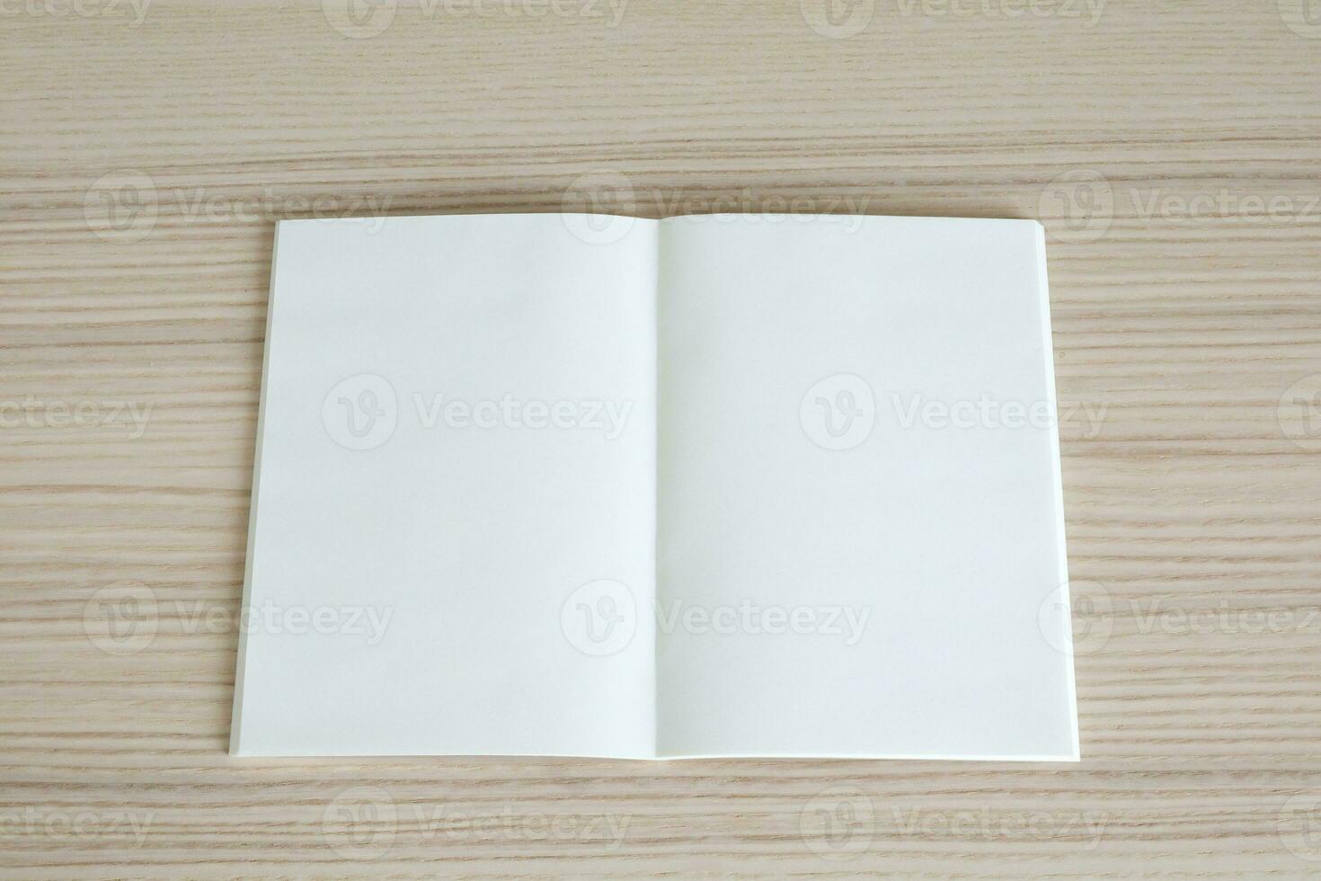 Mock up blank open paper book on wood table background photo