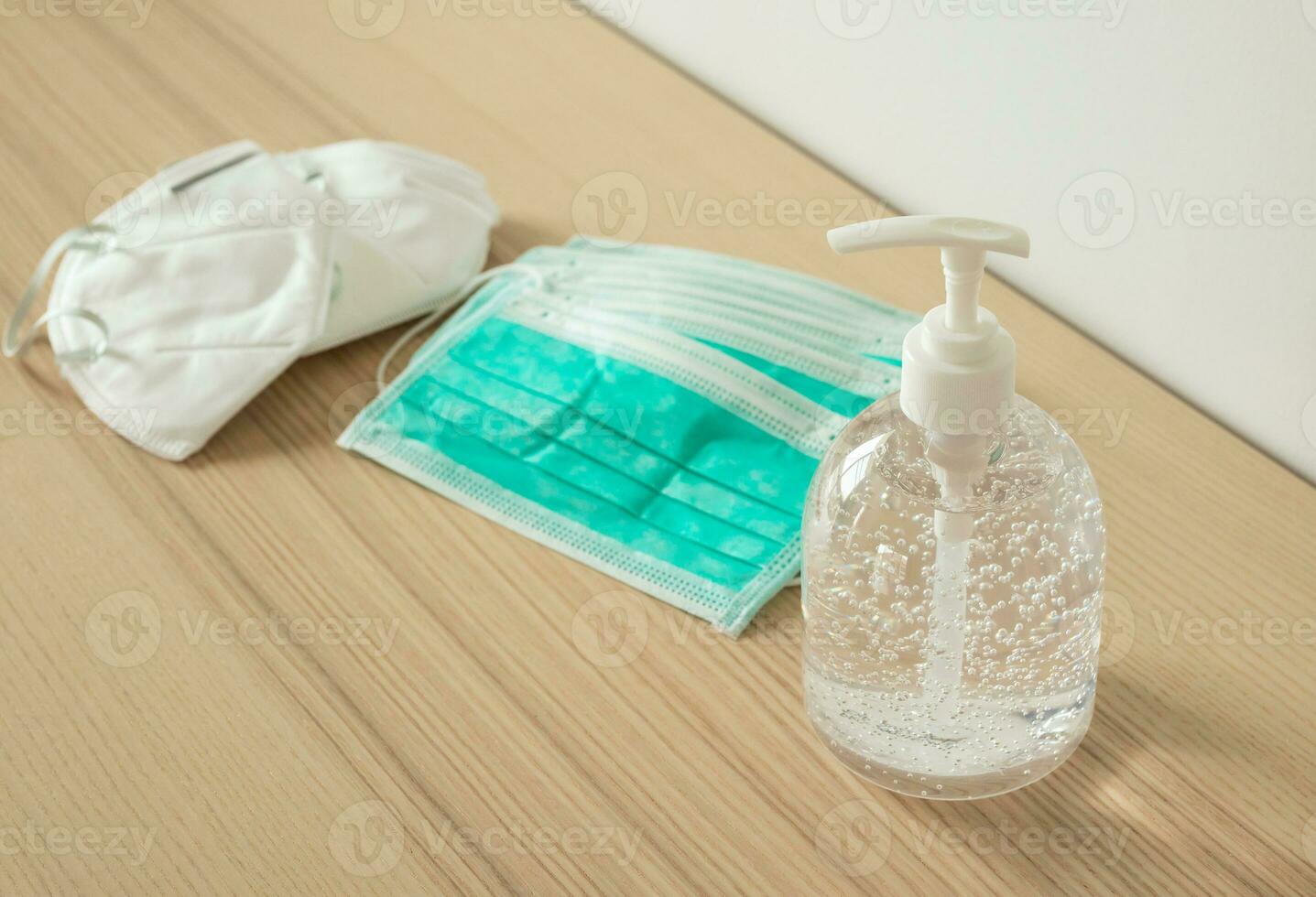 mascarilla médica con gel desinfectante de alcohol lavado a mano en mesa de madera para el concepto de prevención del coronavirus covid-19 foto