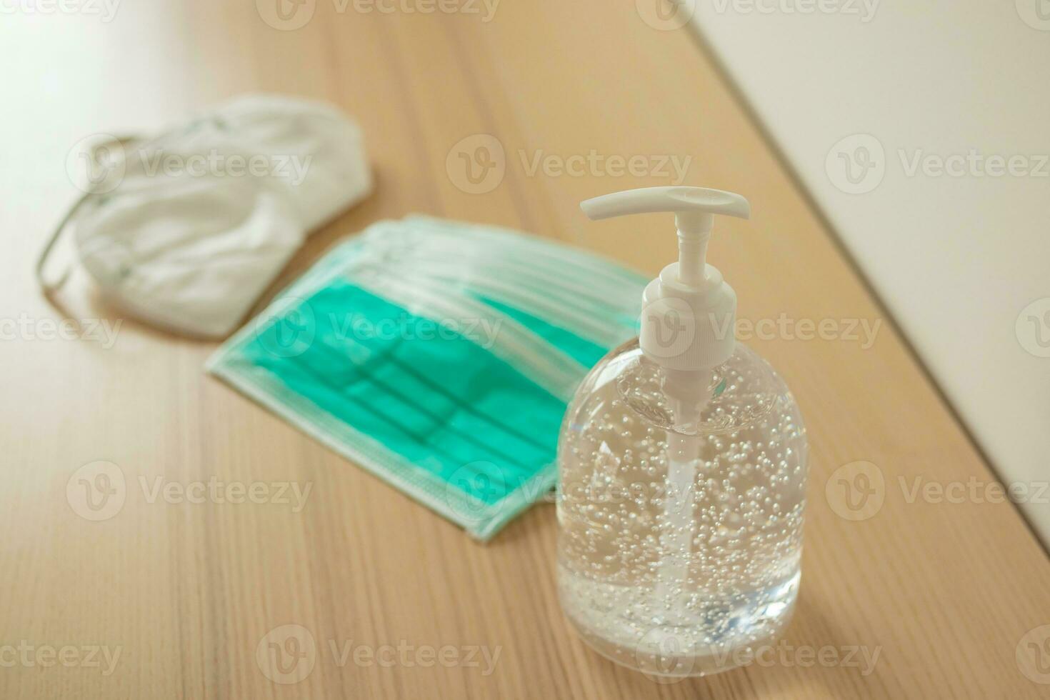 Medical face mask with alcohol sanitizer gel hand wash on wood table for covid-19 Coronavirus prevention concept photo