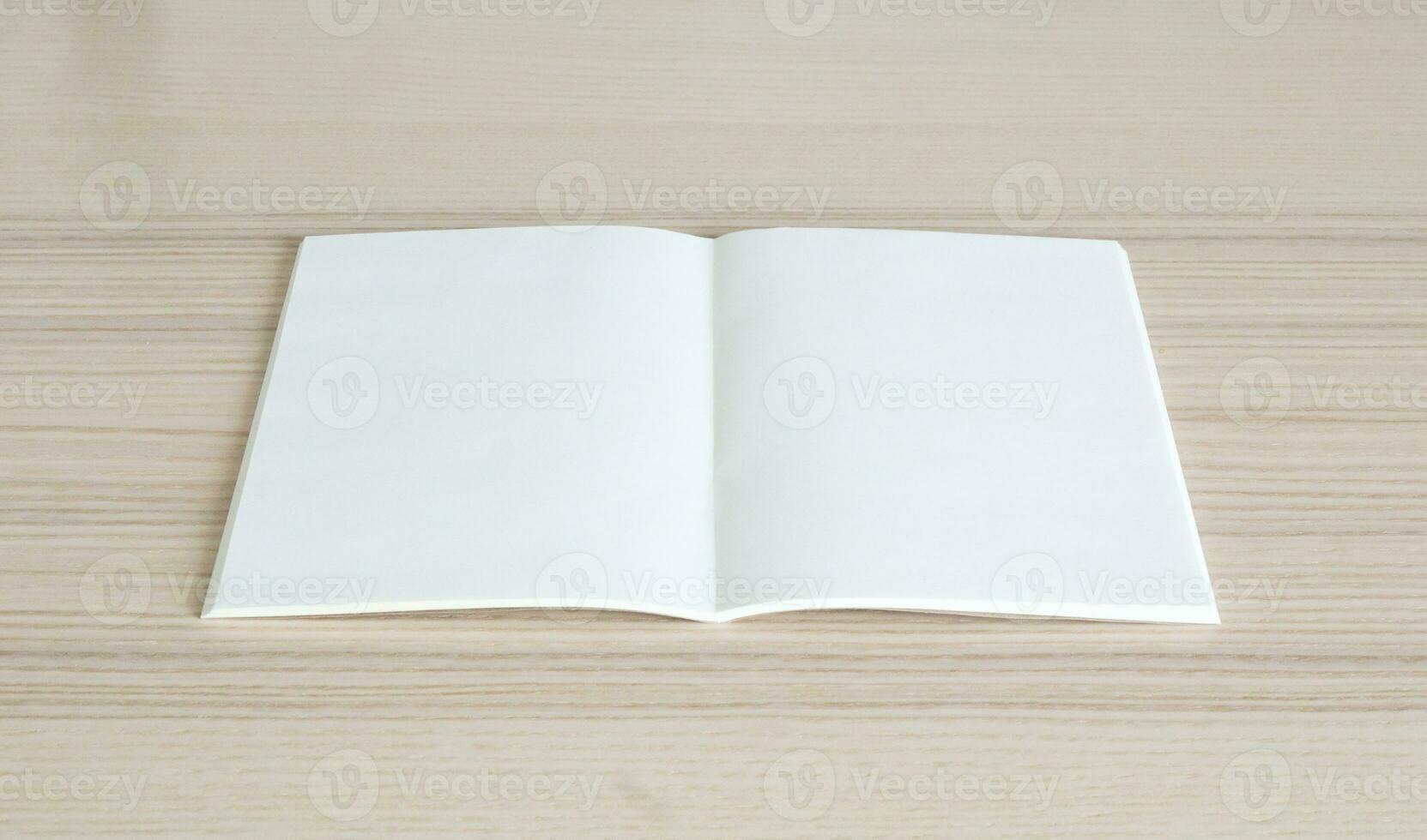 Mock up blank open paper book on wood table background photo