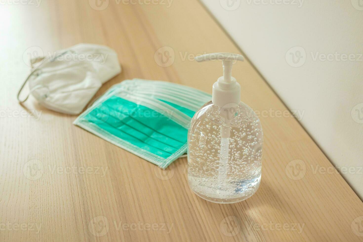 Medical face mask with alcohol sanitizer gel hand wash on wood table for covid-19 Coronavirus prevention concept photo