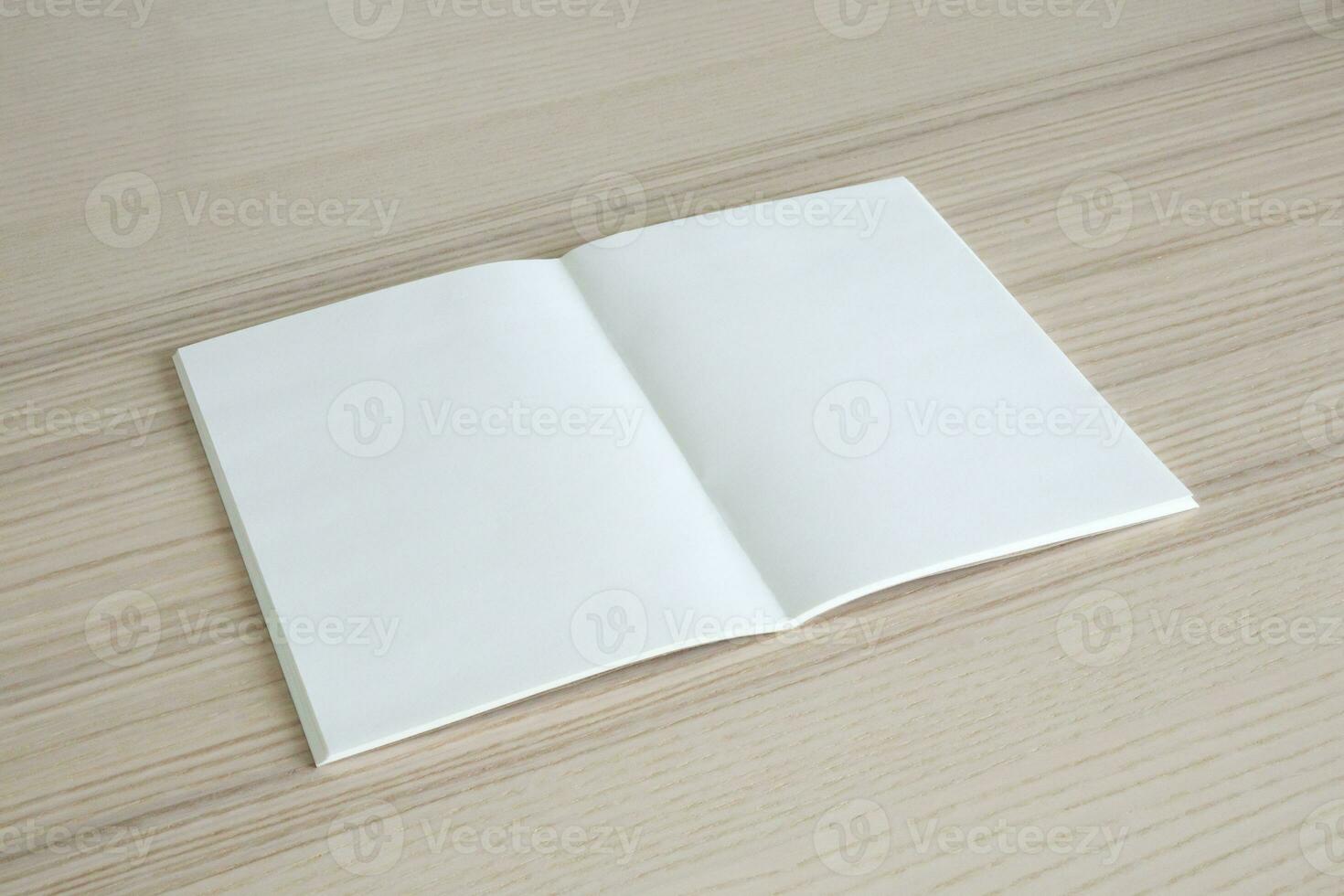 Mock up blank open paper book on wood table background photo