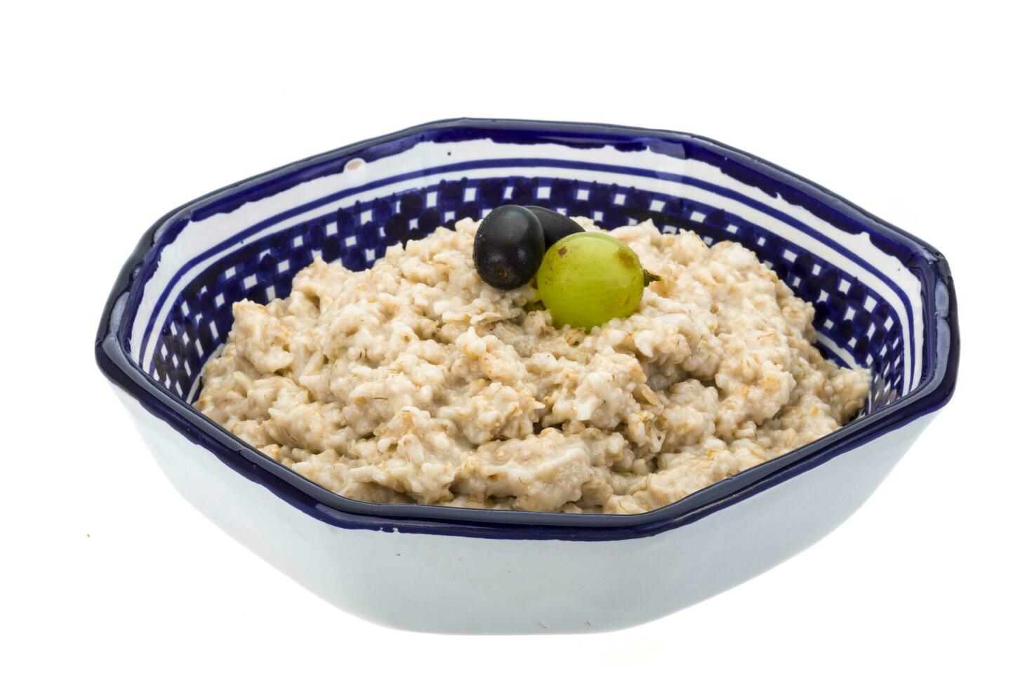 Oats porridge in a bowl on white background photo