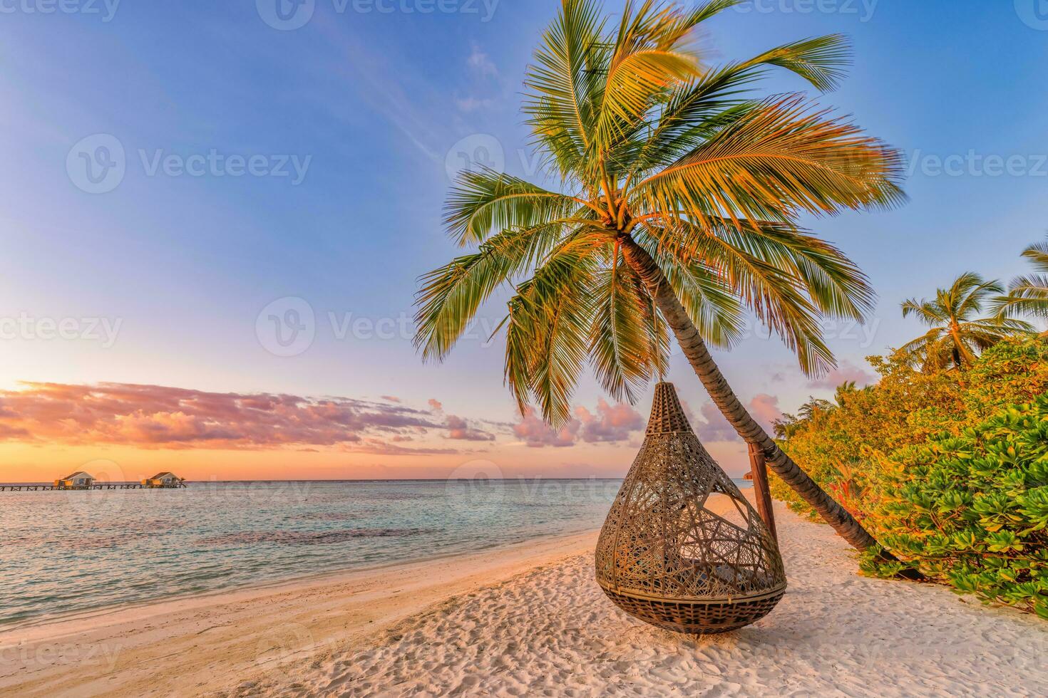 Tropical sunset beach background as summer landscape panorama with beach swing or hammock and white sand and calm sea beach banner. Perfect beach scene vacation or summer holiday concept photo