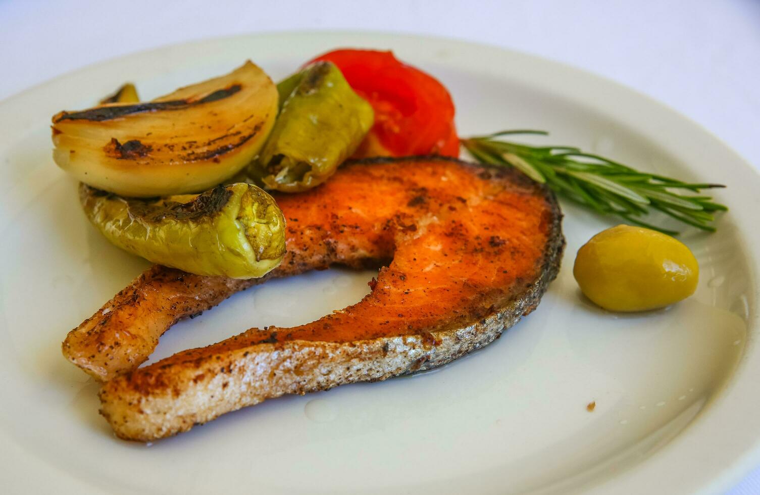 salmón a la parrilla en el plato y fondo blanco foto