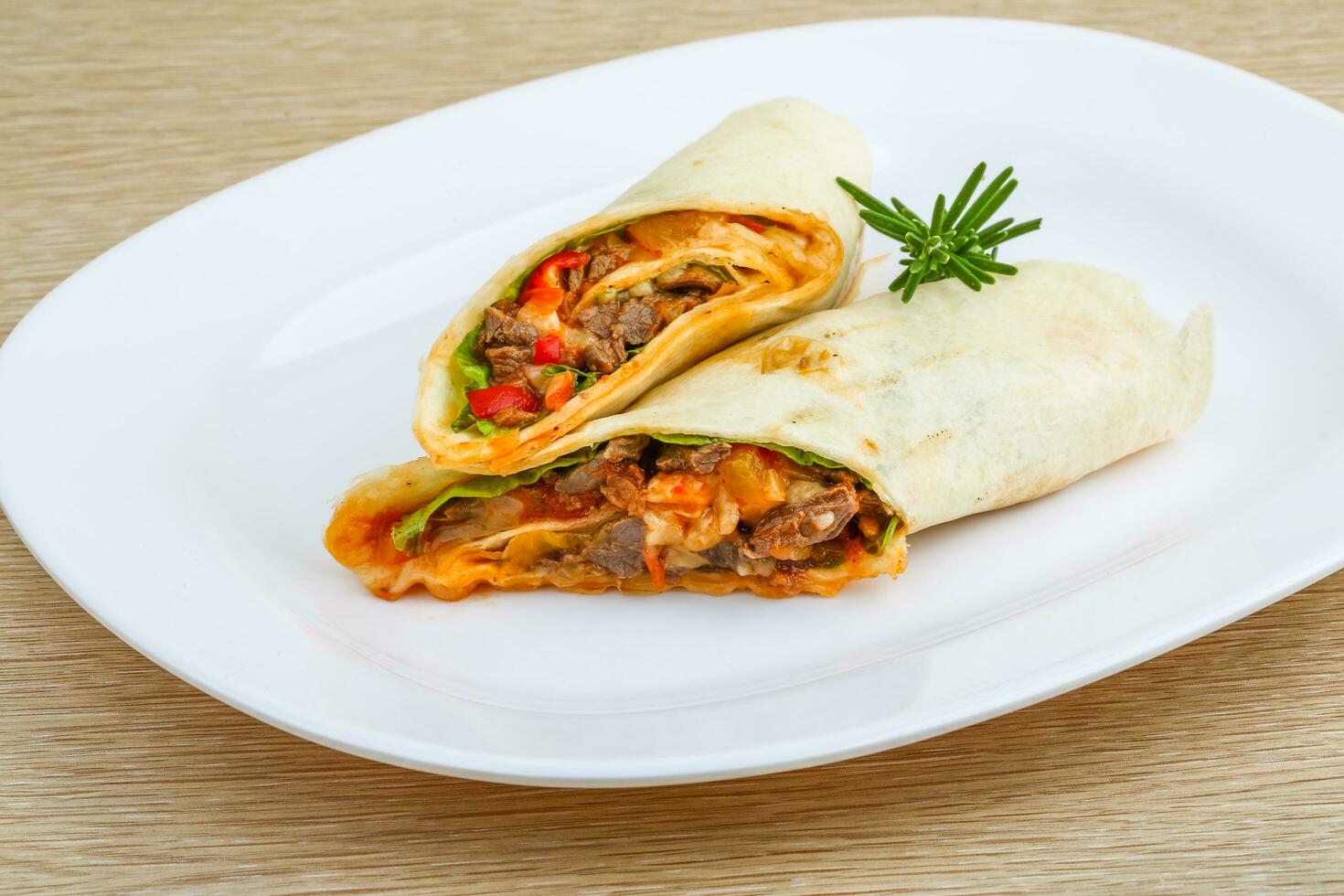 Wrap tortilla on the plate and wooden background photo