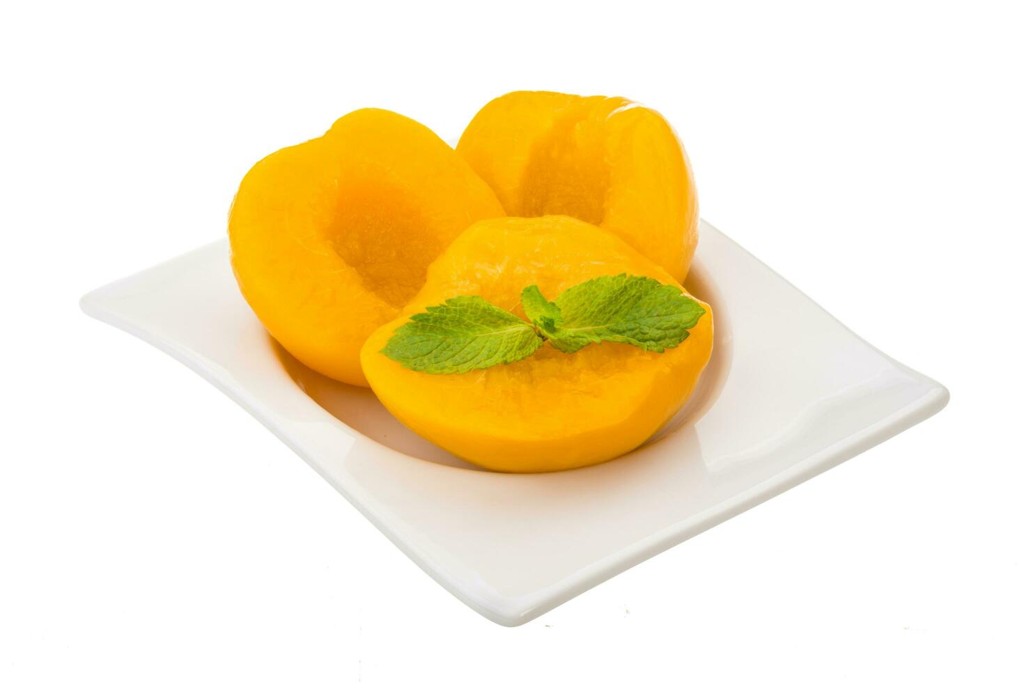 Marinated peaches in a bowl on white background photo