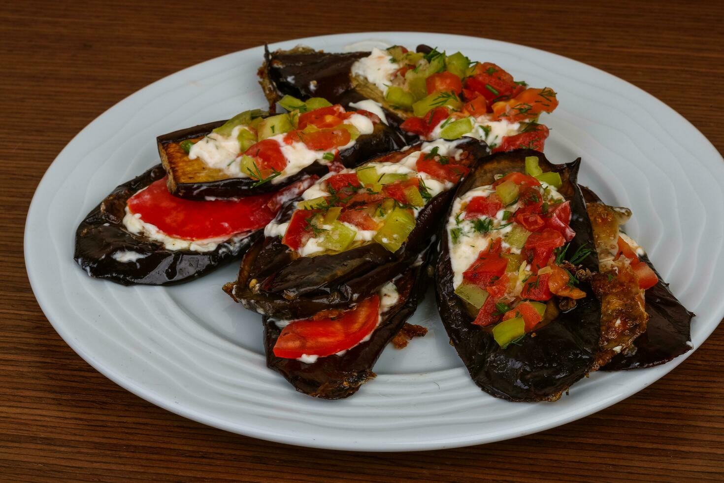 berenjena a la parrilla en el plato y fondo de madera foto