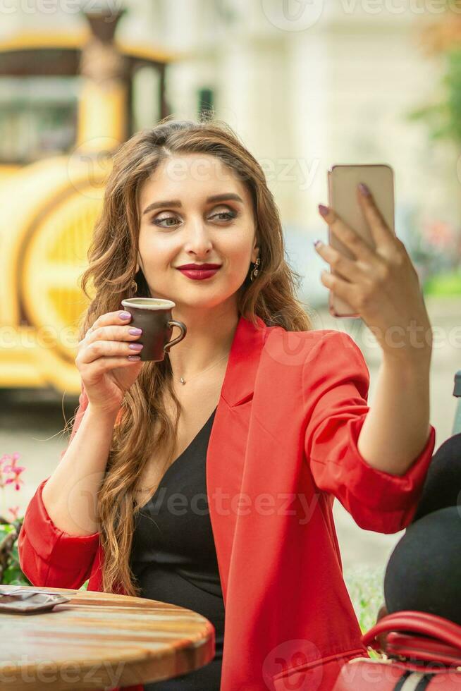 niña feliz tomando selfie en el café al aire libre. foto