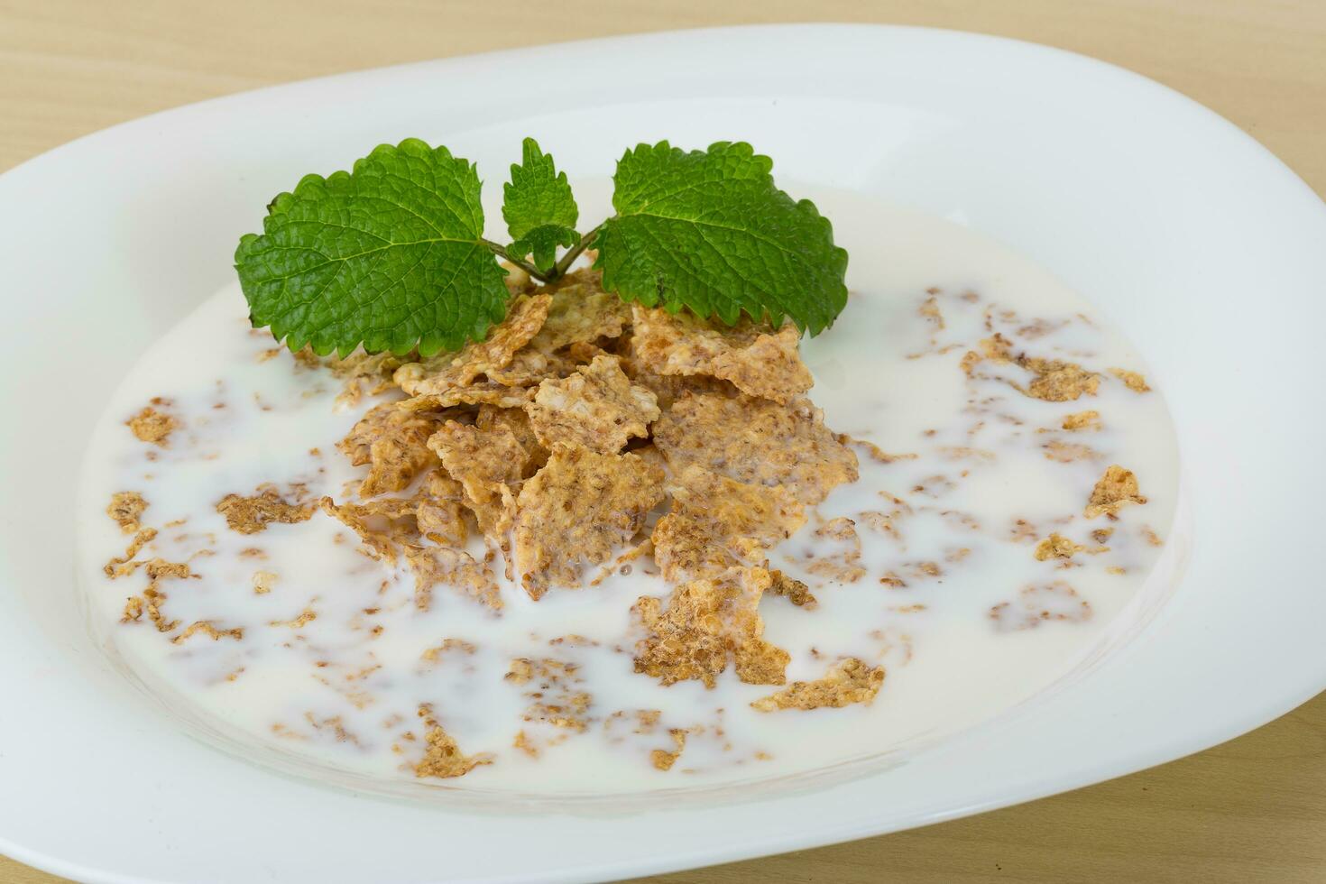 Cornflakes on the plate and wooden background photo