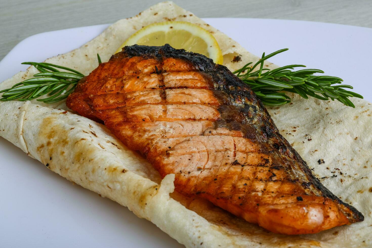 Grilled salmon on the plate and wooden background photo