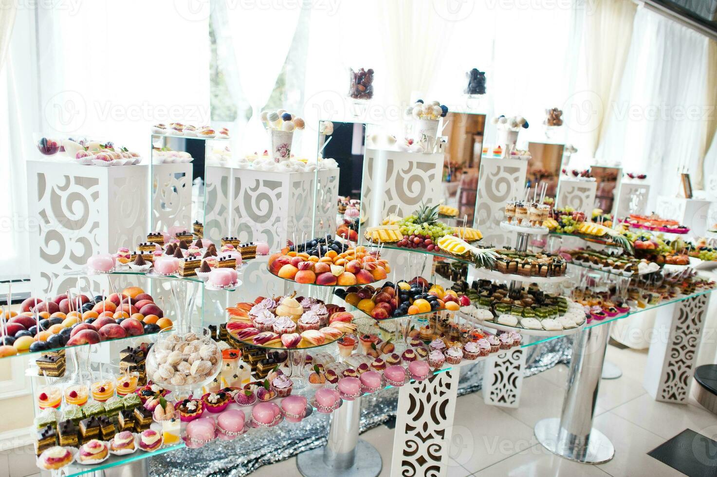 hermosa barra de dulces de boda con dulces, frutas y comida. mesa de banquete de boda foto