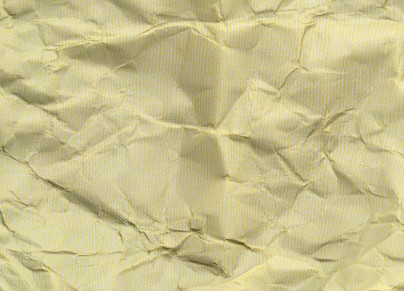 Yellow crumpled paper background with pattern for design photo
